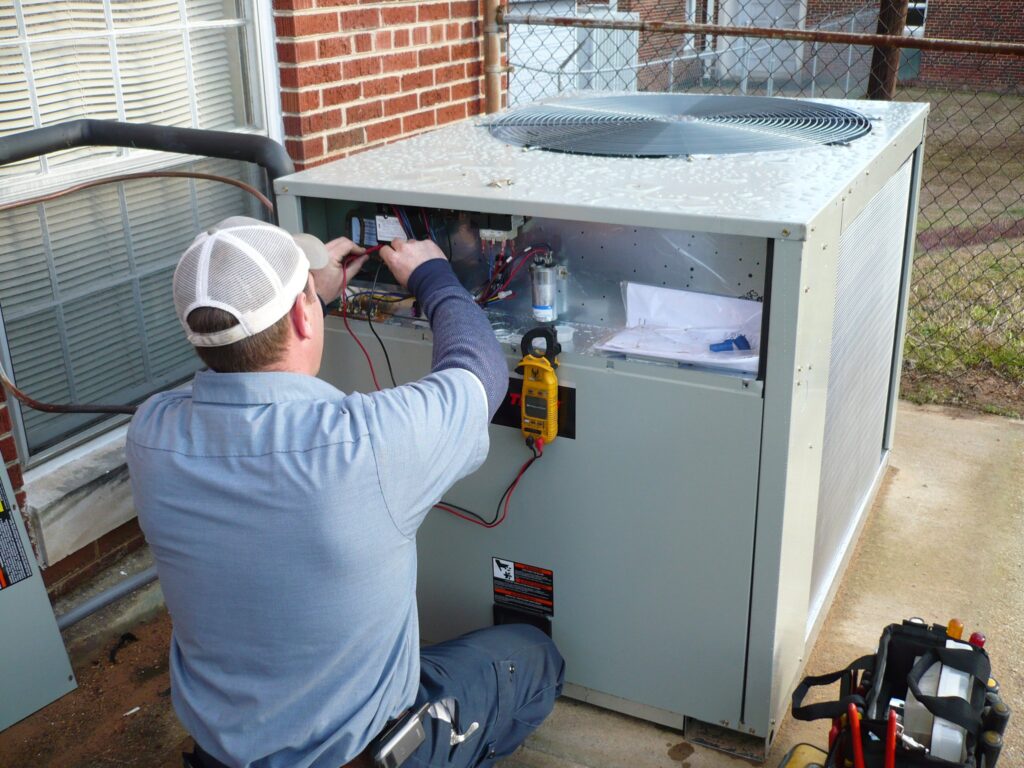 man performing AC maintenance on a unit